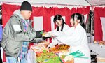 購入した参拝者に縁起物を手渡す福娘＝１０日、新温泉町芦屋の宇都野神社