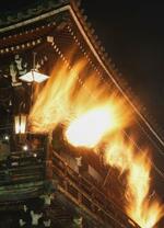 　東大寺二月堂で行われた「お水取り」で、世話役の「童子」が欄干から籠たいまつを突き出して走ると暗闇に火の粉が降り注いだ＝１２日夜、奈良市（多重露光）