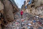 　プラスチックごみなどが散乱した線路を歩く男性＝４月、インド・ムンバイ（ＡＰ＝共同）