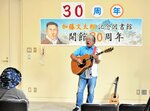 下山後のミニライブで歌声を披露するリピート山中さん＝１２日、新温泉町浜坂の加藤文太郎記念図書館