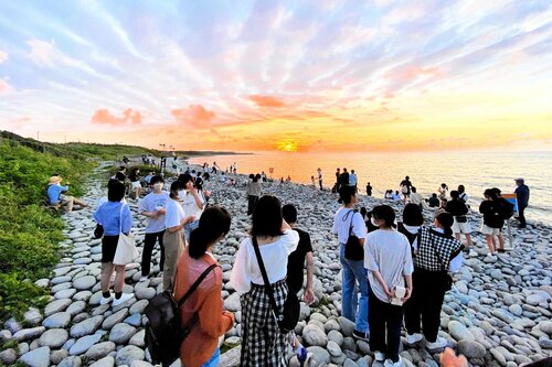 祭りのメインイベント「夕日の鑑賞会」で夕日に見入る来場者ら