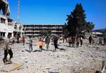 　破壊された国連パレスチナ難民救済事業機関の施設に集まる人たち＝１２日、ガザ市（ロイター＝共同）