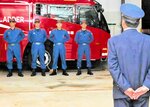 井崎消防長（右）に帰任報告をする隊員たち＝２１日、豊岡市昭和町の市消防本部