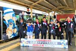 新デザインのコナン列車の出発を決めポーズで見送る関係者ら＝１６日、鳥取県北栄町由良宿のＪＲ由良駅