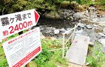 大雨の影響で崩落した遊歩道入り口の鉄製の橋（右手前）。復旧は来年度以降になる見込み＝８月３０日、新温泉町岸田の霧ケ滝渓谷