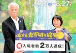 安田理事長（左）から２万人目の祝福を受ける海原さん＝８日、境港市の夢みなとタワー