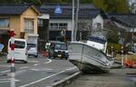 　津波で歩道に打ち上げられた船＝７日、石川県七尾市の能登島