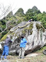 御子岩に新調したしめ縄を掛ける参加者ら＝１４日、鳥取市河原町の霊石山
