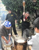 かけ声に合わせて餅をつく参加者＝１日、鳥取市立川町５丁目の鳥取こども学園