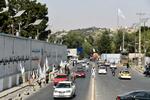 　白いタリバン旗を売る露天商（左）と行き交う車＝３１日、アフガニスタン・カブール中心部（共同）