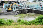 清水川排水機場の取水口にたまった草を取り除く作業員ら＝１３日、鳥取市吉成南町１丁目
