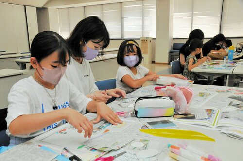 相談しながら紙面を制作する親子＝２９日、鳥取市富安２丁目の新日本海新聞社本社