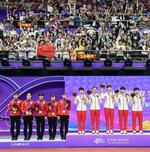　卓球女子団体で優勝した中国チーム（右）と盛り上がる観客。左は銀メダルの日本チーム＝９月２６日、杭州（共同＝ソン・ホウ撮影）」
