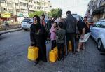 　２０日、パレスチナ自治区ガザで水を求めて待つ住民ら（ゲッティ＝共同）