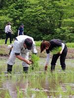 　避難指示が一部で解除された福島県浪江町の津島地区で、１４年ぶりに田植えをする元住民ら＝２３日午前、福島県浪江町