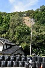 　土砂災害の様子を見る工事関係者＝７月２５日、石川県輪島市