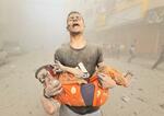 　１０月３１日、パレスチナ自治区ガザで、負傷した子どもを抱える男性（ゲッティ＝共同）
