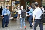 　京成電鉄柴又駅前で上智大生殺害事件の情報提供を求めるチラシを配る警察官＝９日午前、東京都葛飾区