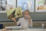 　絵本「メチのいた島」を紙芝居にして、集まった人たちに読み聞かせる杉原由美子さん＝１９日午後、松江市