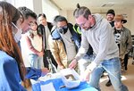 地震で起こる液状化現象を実験で学ぶ参加者ら＝２８日、三朝町総合文化ホール