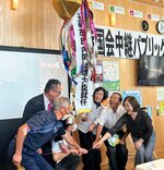 くす玉を割って石破首相の誕生を祝う地元関係者ら＝１日、八頭町郡家のＪＲ郡家駅前