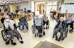 　特別養護老人ホーム「三思園」の体操の時間。入所者は共用スペースに集まって体を動かす＝２０２４年５月、青森市