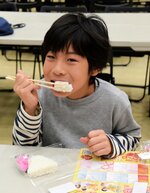 おいしい　「甘くておいしい」。新米のおにぎりを頰張る子ども