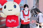 啓発グッズを来店者に手渡し献血への協力を呼びかける高校生（中央）＝１６日、鳥取市晩稲のイオンモール鳥取北