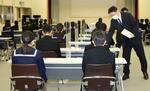 　集団避難先から金沢市の会場に入り、入学試験に臨む受験生＝６日午前