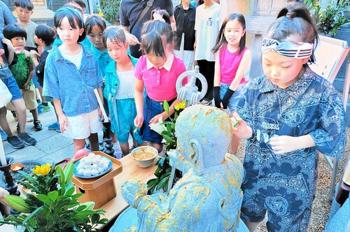 願いを込めて地蔵にみそを塗る子どもたち