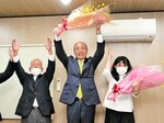 両手を掲げ３選を喜ぶ陶山さん（中央）＝８日午後５時４０分、南部町阿賀の選挙事務所