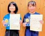 頂点に立った女子小学３、４年３６㌔級の田中弥愛（左）と同小学５、６年３３㌔級の岡田晏奈＝松山市の久米中