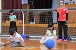 浦田さん（右）の指導を受けながらゴールボールを体験する参加者＝２２日、鳥取市国府町宮下の鳥取盲学校