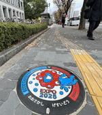 　大阪市役所前の歩道に設置された、大阪・関西万博の公式キャラクター「ミャクミャク」をデザインしたマンホールのふた