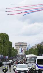 　カラースモークでパリ上空を彩る空軍機。奥は凱旋門＝１４日（共同）