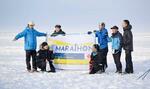 　「別海アイスマラソン」の横断幕を掲げる参加者ら＝２０２３年２月、北海道別海町（同実行委提供）