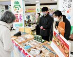 地元産品を使った商品を買い求める来店客（左）＝１０日、米子市末広町のイオン米子駅前店