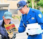 買い物客に啓発チラシを手渡して交通安全を呼びかける隊員＝１５日、倉吉市西倉吉町の旬鮮プラザ満菜館