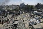 　イスラエル軍による攻撃があったガザ南部ハンユニスの現場で、被害状況を調べるパレスチナ人ら＝１３日（ＡＰ＝共同）