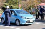 　東通原発１号機の重大事故に備えた防災訓練で、国道に合流しようとする車両に乗ったＵＰＺ住民役に自宅で待機するよう促す警察官＝９日午前、青森県東通村