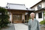 熊本地震で被災し、再建した本堂の前に立つ浄福寺の住職浄住護雄さん＝２０２４年５月、熊本市
