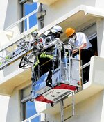 客室内の要救助者を窓から救助する消防隊員