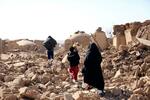 　アフガニスタン西部を襲った地震で、がれきの上を歩く女性と子どもら＝１５日（セーブ・ザ・チルドレン提供・ＡＰ＝共同）