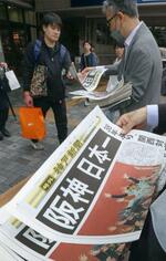 　神戸市内で配られた、阪神の日本一を伝える神戸新聞の号外＝６日午前