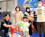掃部館長（左）から記念品を受け取る関谷瑛翔ちゃんと家族＝１９日、境港市の夢みなとタワー