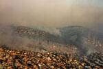 　３日、チリ中部バルパライソ郊外で煙に包まれる市街地（ゲッティ＝共同）