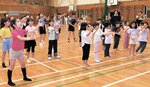 歌を口ずさみながら手話踊りの練習に励む子どもたち＝１６日、鳥取市行徳１丁目の明徳小体育館