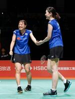 　女子ダブルス準決勝で中国ペアに勝利し、タッチを交わす福島由紀（左）、松本麻佑組＝熊本県立総合体育館