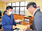 担任（右）から通知表を受け取る児童＝２４日、新温泉町栃谷の浜坂南小