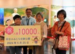 １万人目の入園者となった宮内さん（左）ら＝２５日、鳥取市青谷町吉川の青谷かみじち史跡公園